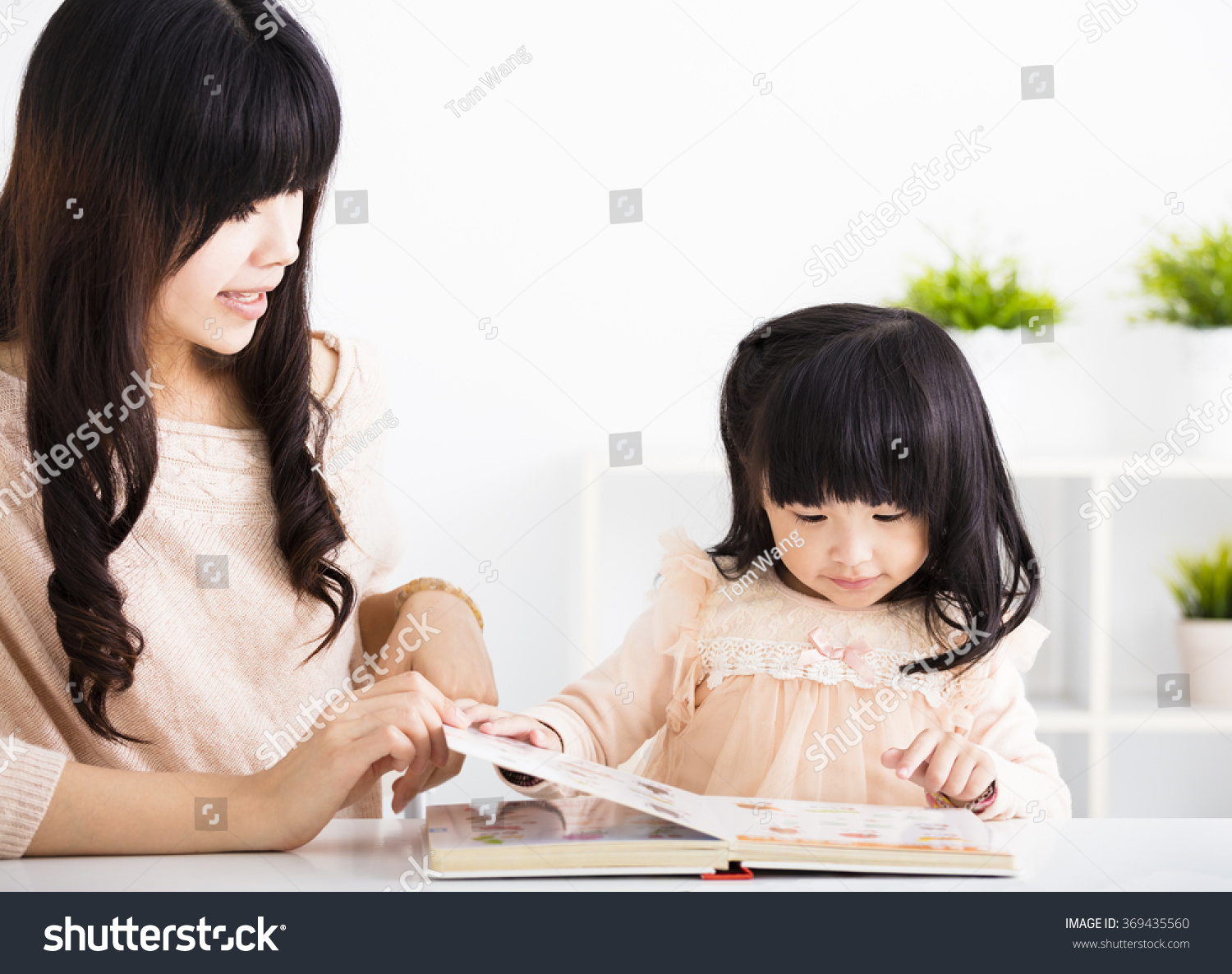 Mother  helping child daughter to reading
