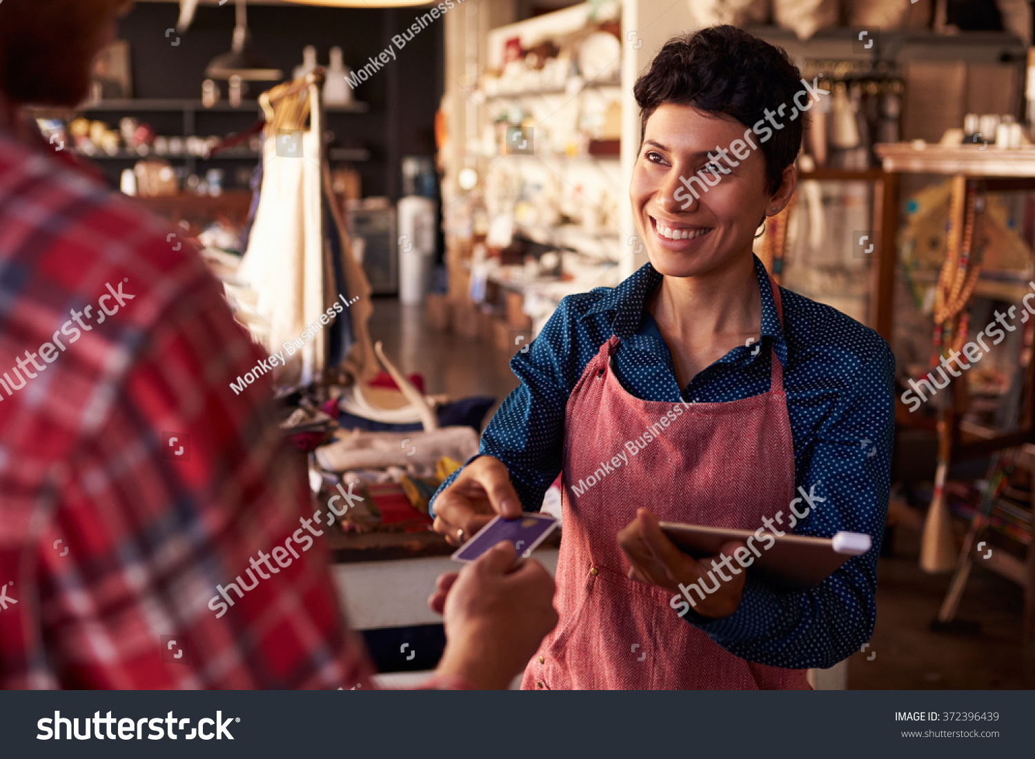 Sales Assistant With Credit Card Reader On Digital Tablet