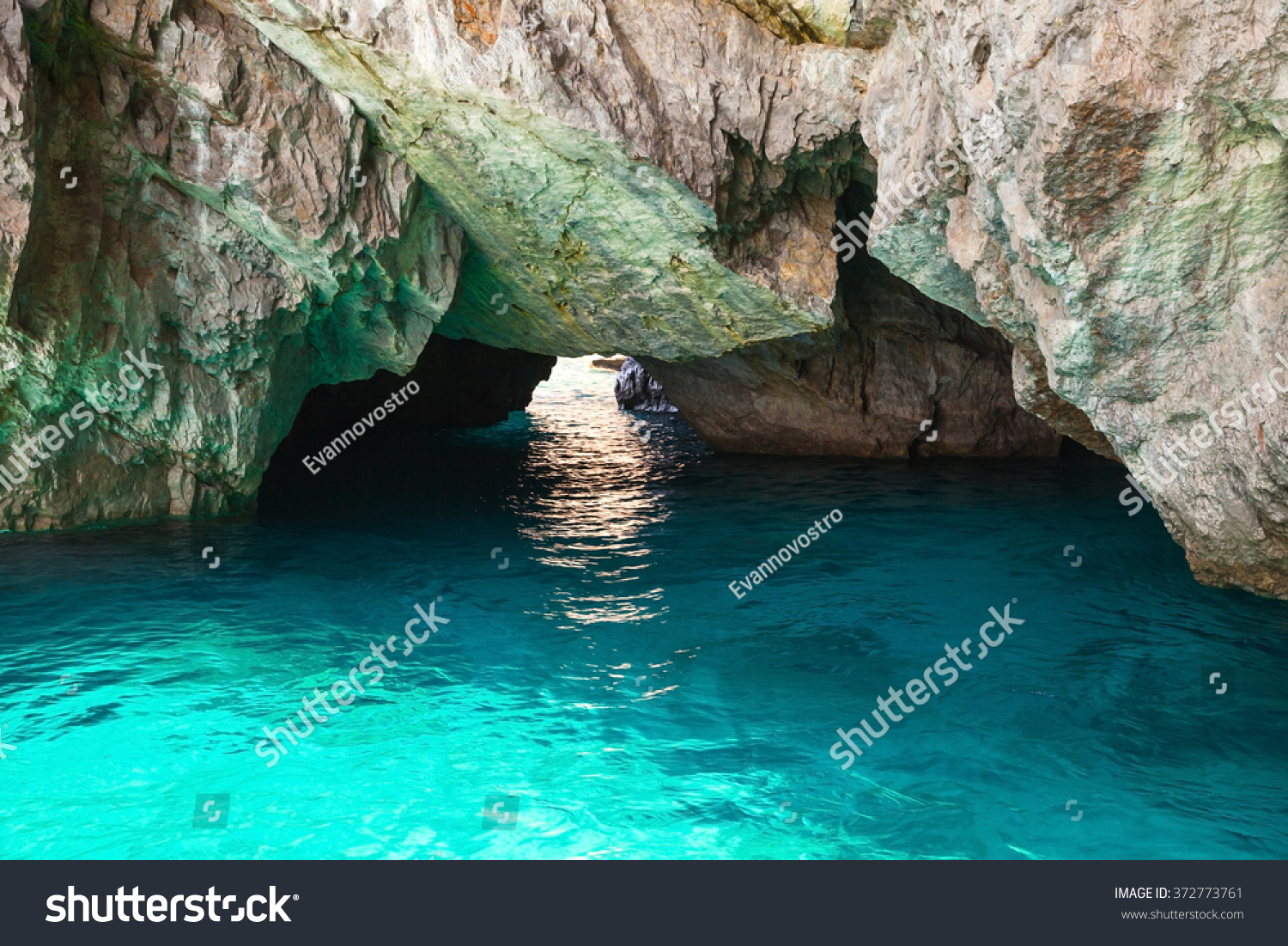 Coastal rocks of Capri island  small empty grotto with shining sea water inside
