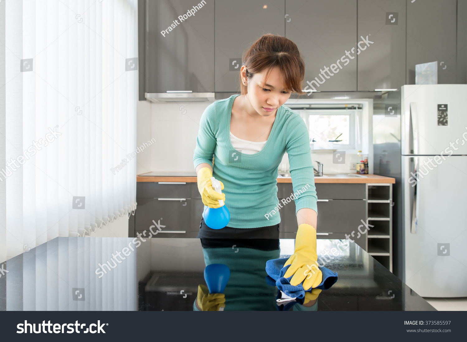 Asian Young Woman Cleaning Modern Kitchen at Home