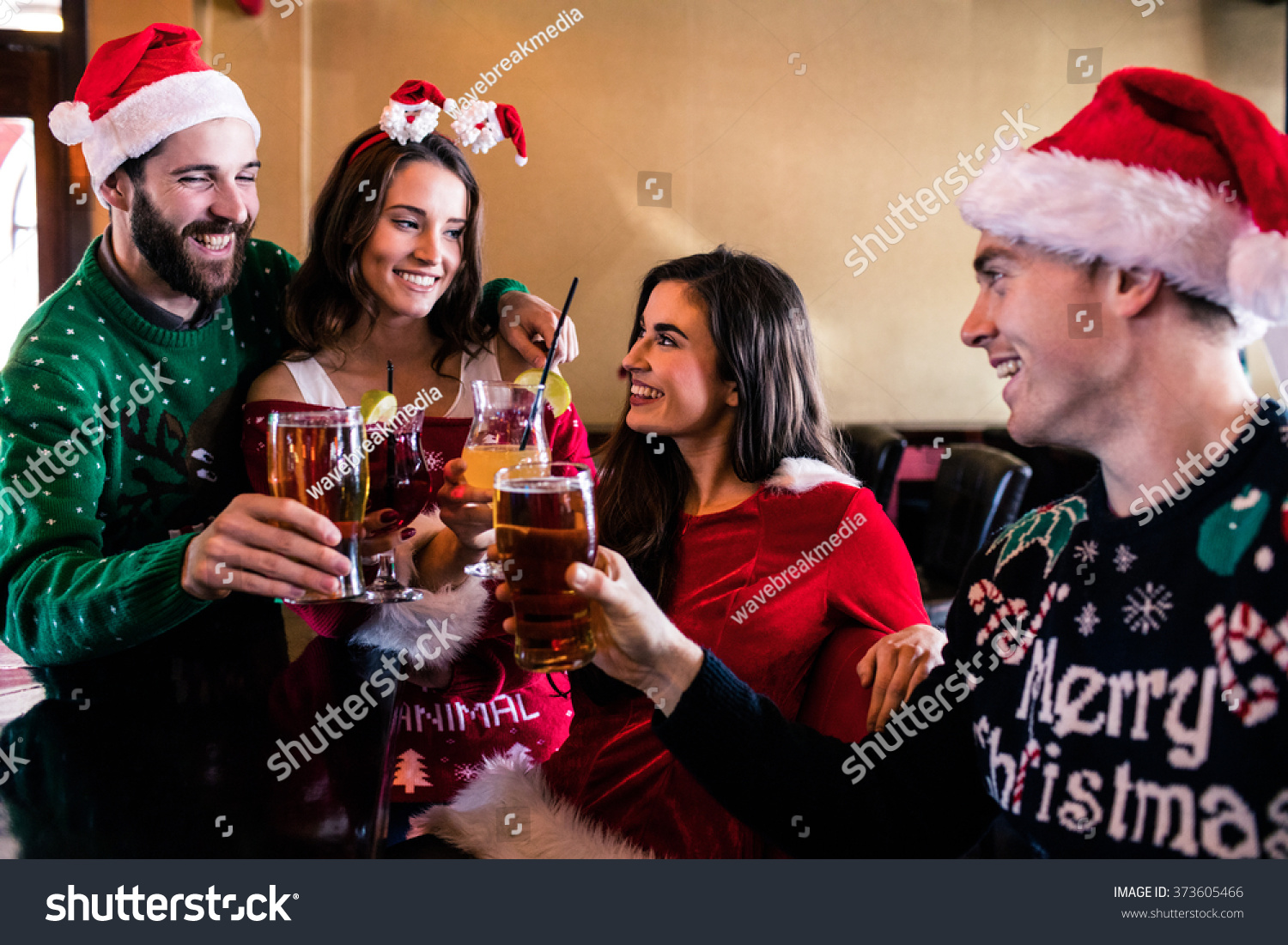 Festive friends drinking beer and cocktail in bar