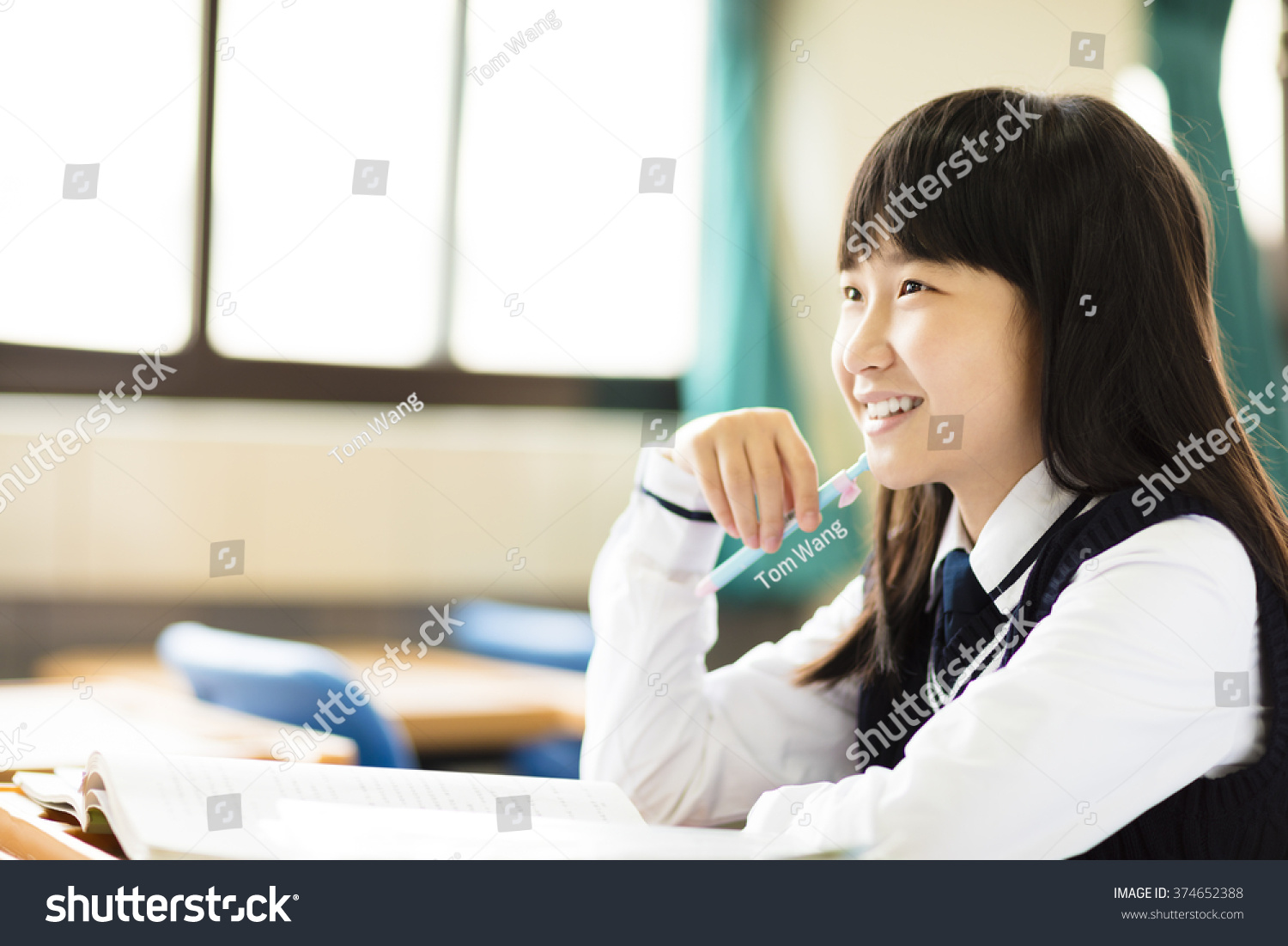 happy pretty  student girl with books in classroom