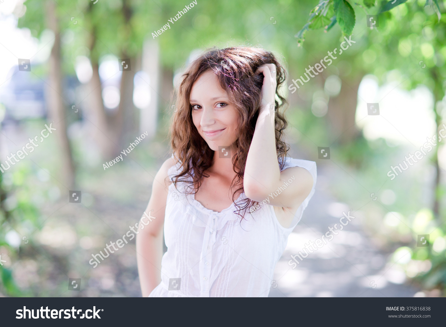 Summer portrait of young attractive girl posing in the park