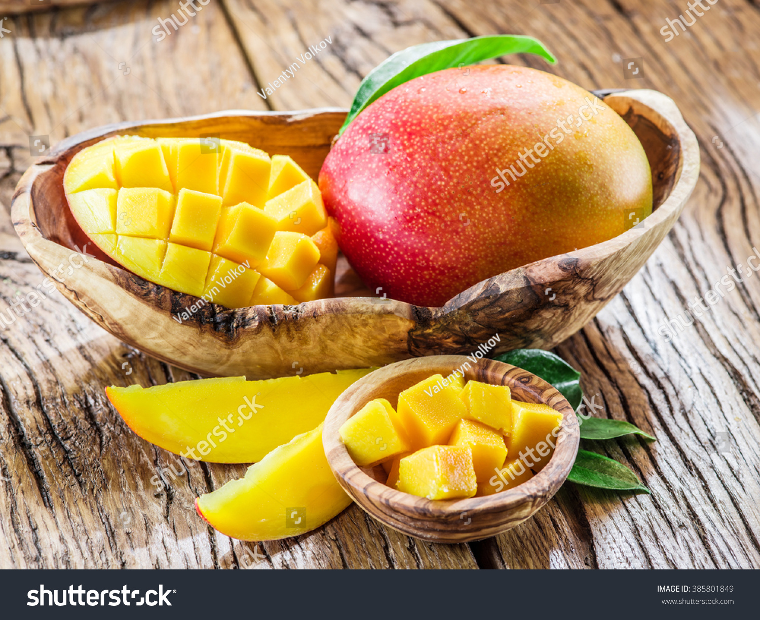 Mango fruit and mango cubes on the wooden table.