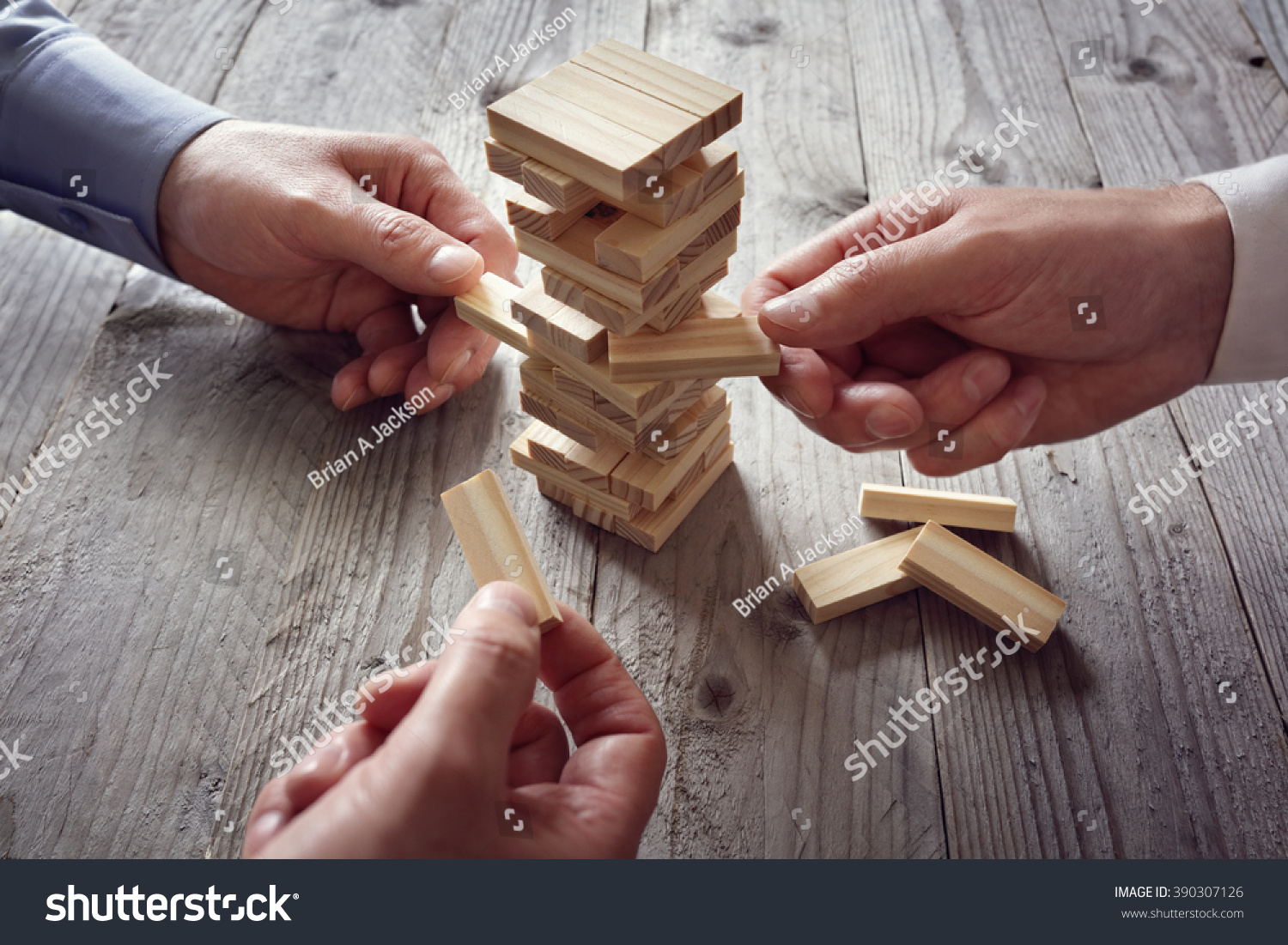 Planning risk and team strategy in business businessman gambling placing wooden block on a tower