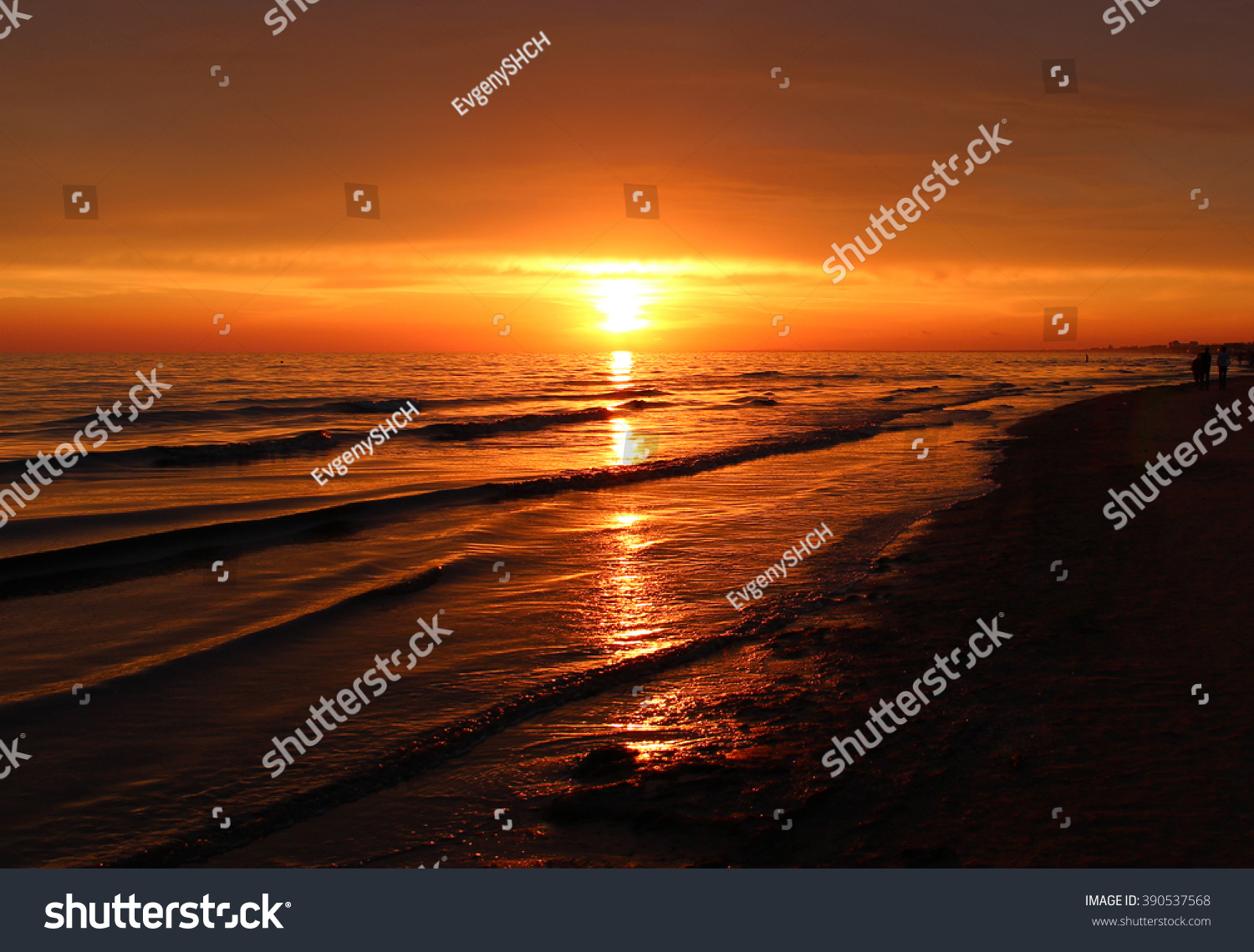 Beautiful blazing sunset landscape at black sea and orange sky above it with awesome sun golden reflection on calm waves as a background. Amazing summer sunset view on the beach. Russian nature Sochi