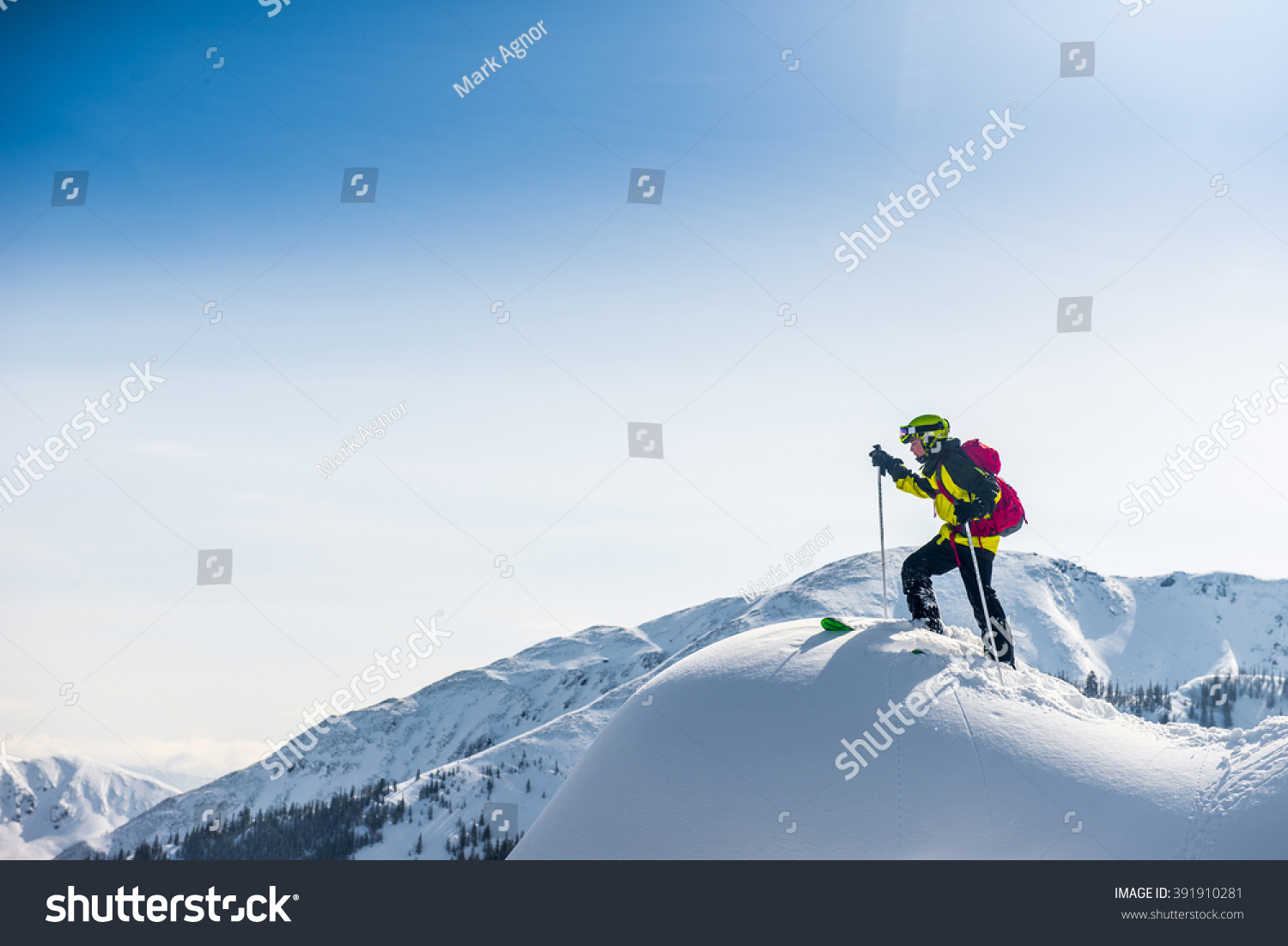 Skier walking on top of the mountain.