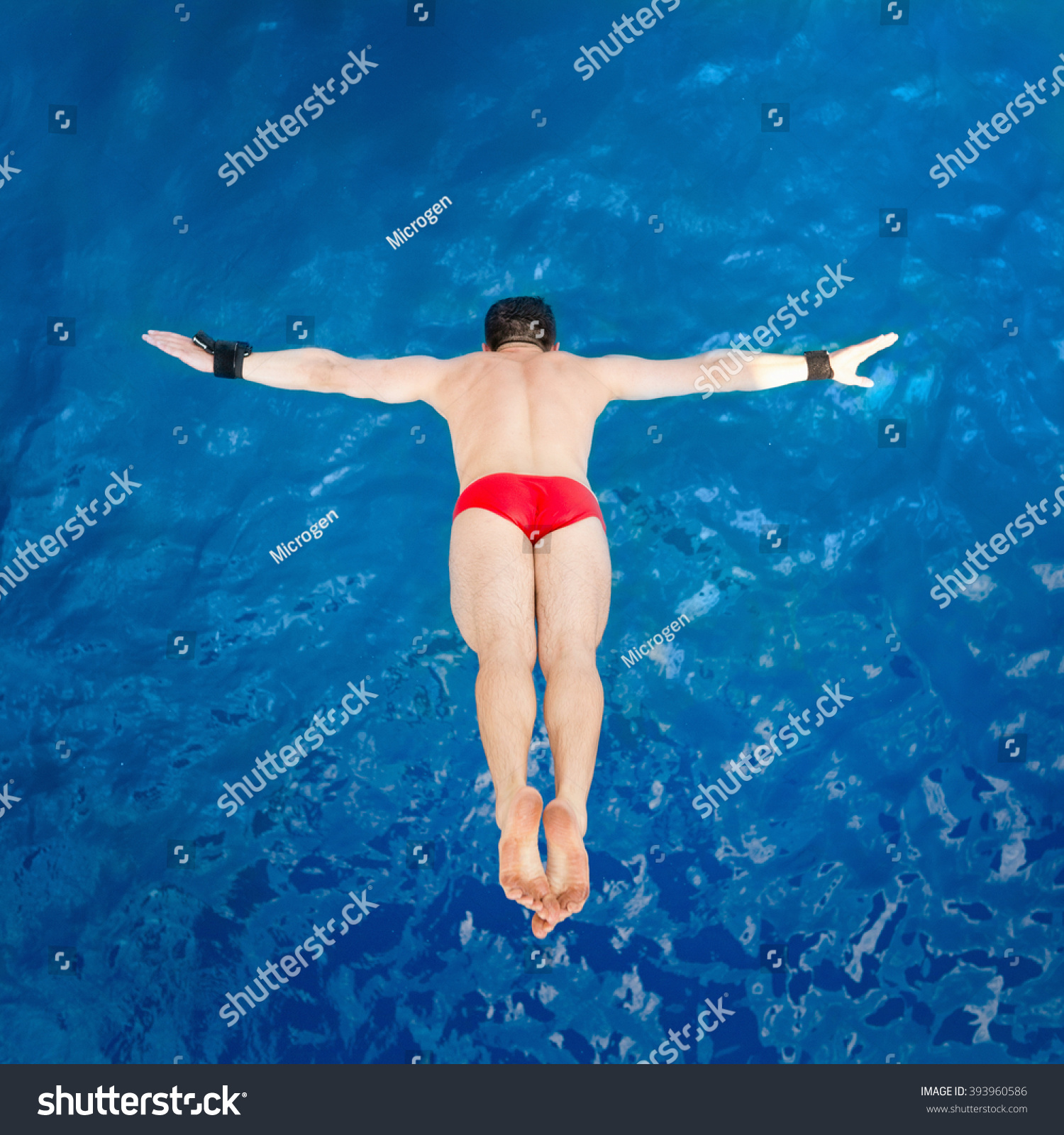 High diver  flying towards water from diving platform  shot from above