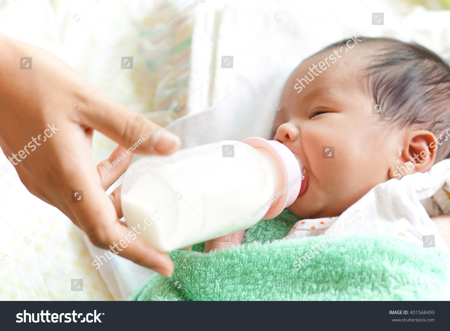 Asian newborn baby drinking milk from bottle