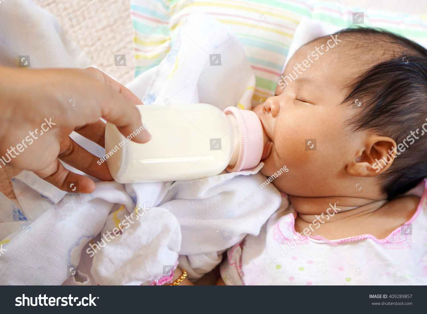  Asian newborn baby drinking milk from bottle                            