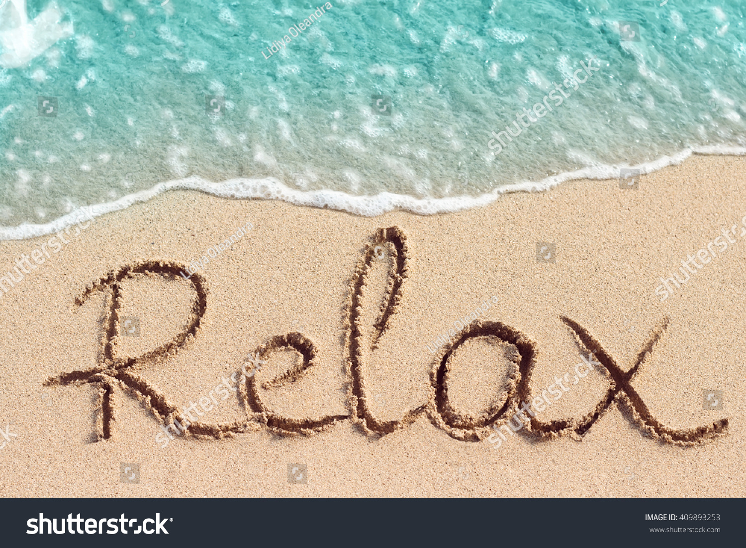Word Relax handwritten on sandy beach
