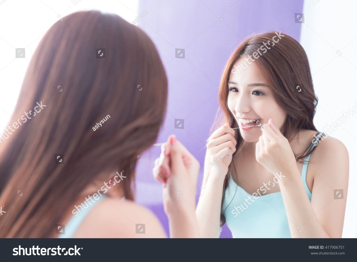 Close up of Smile woman clear teeth by floss and look mirror. great for health dental care concept. asian beauty