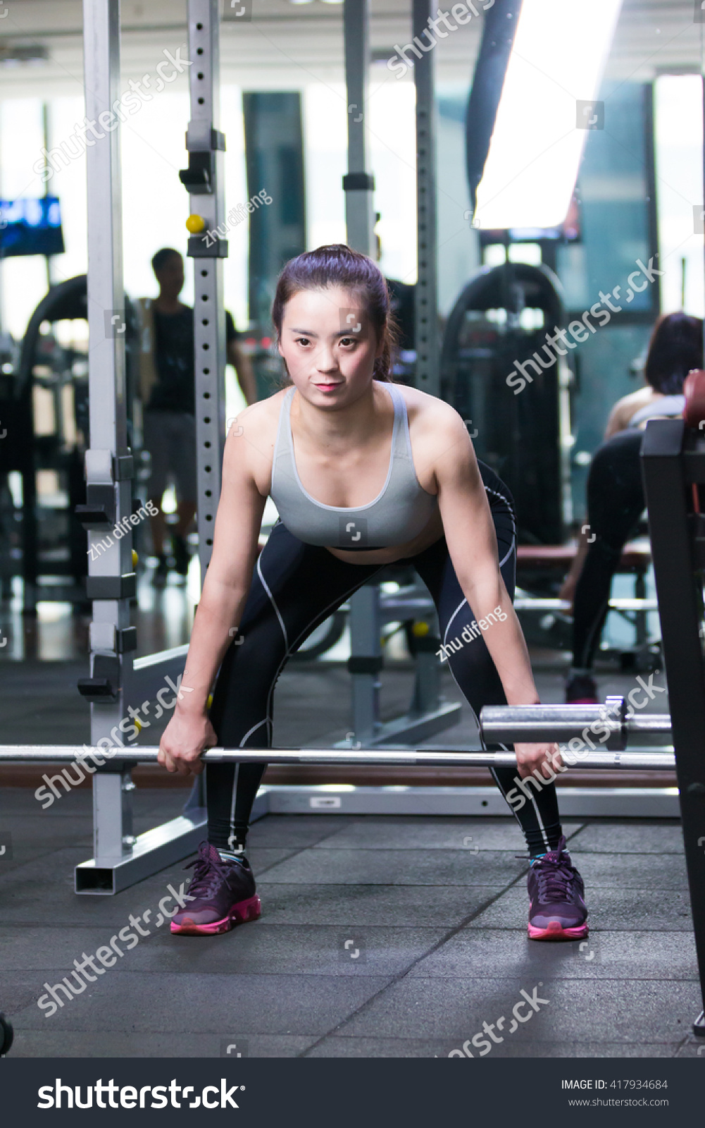 young asian girl working out in modern gym