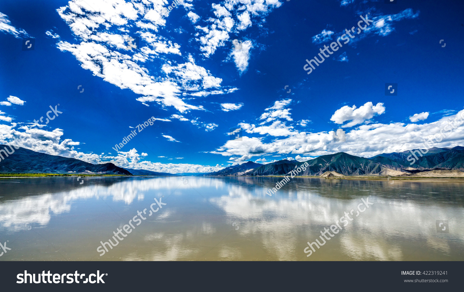 The wide and calm Yarlung Tsangpo river under the blue cloudy sky in Tibet  China
