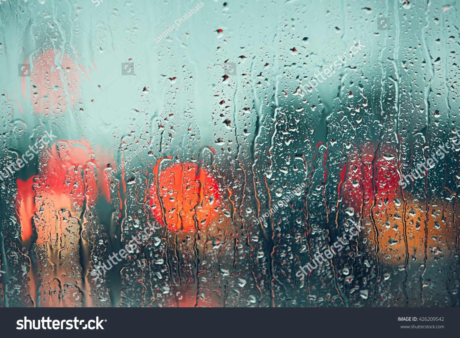 Heavy rain. Raindrop on the window of the car. Abstract blur bokeh of traffic and car light.
