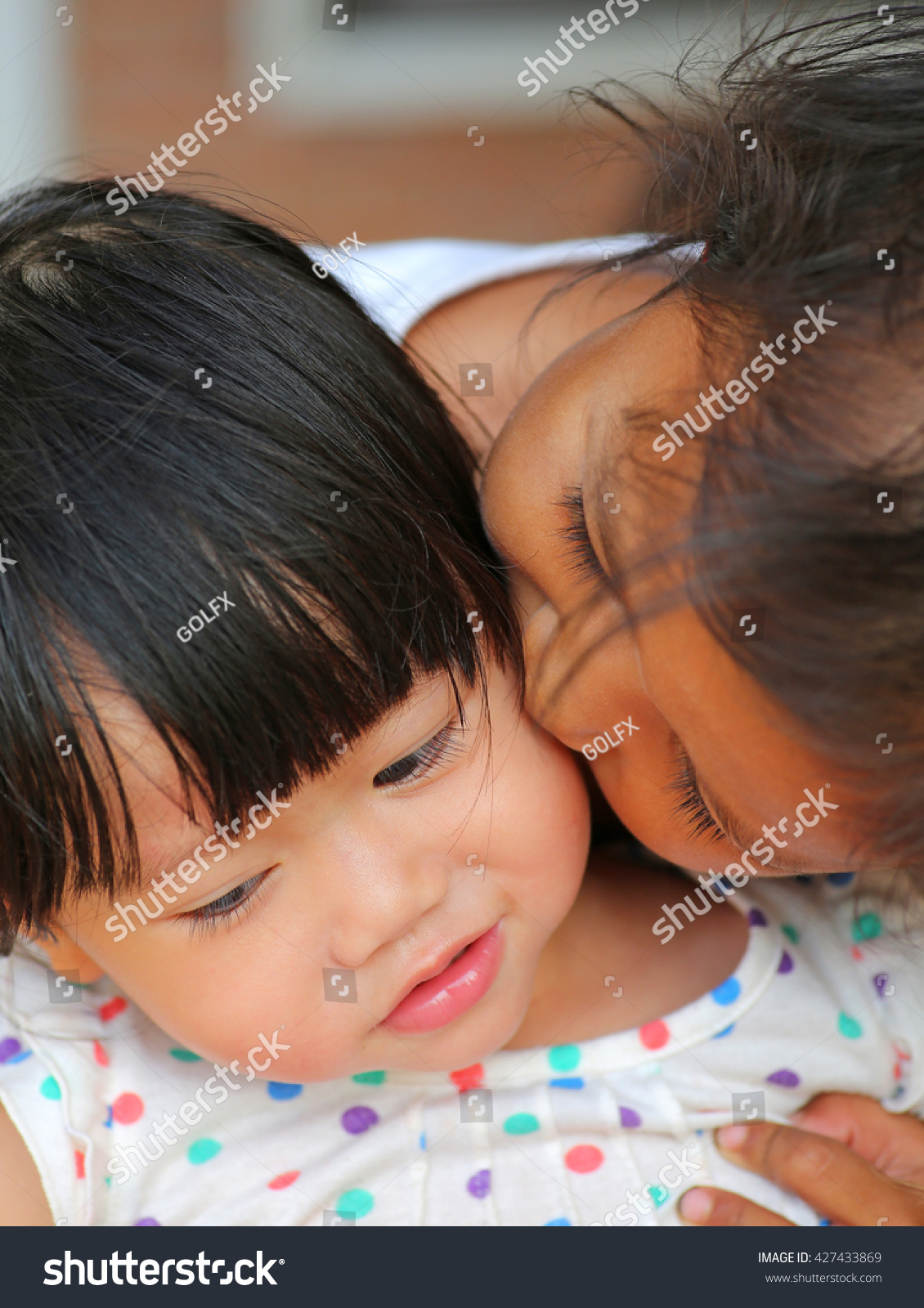 older sister kissing younger sister