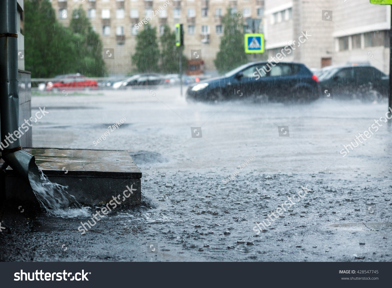 Rain water flowing from metal downspout during a flood. concept of protection against heavy downpours.