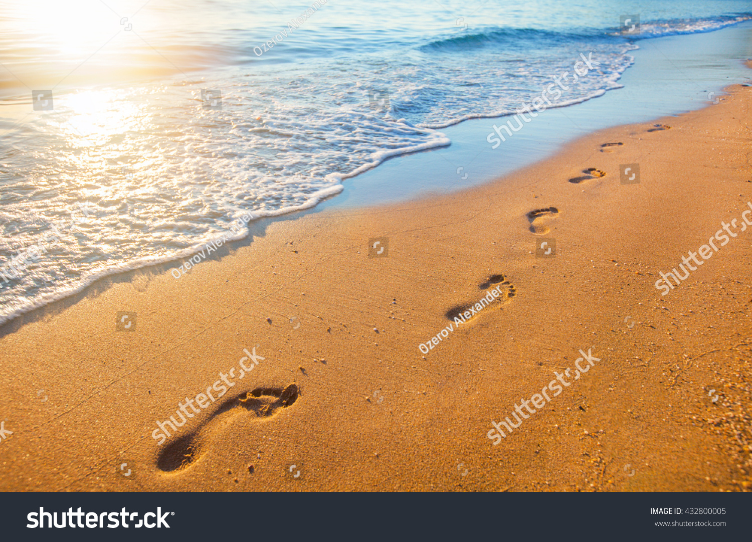 beach  wave and footprints at sunset time