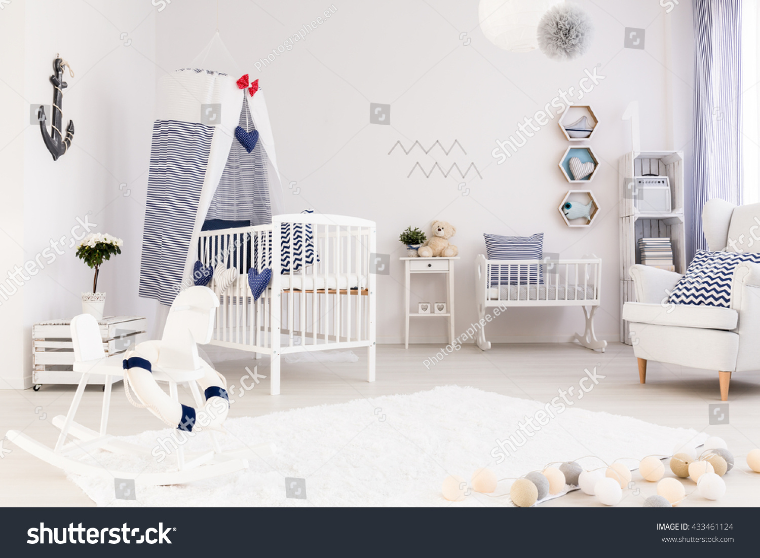 Spacious baby room with simple white furniture and beautiful marine decorations