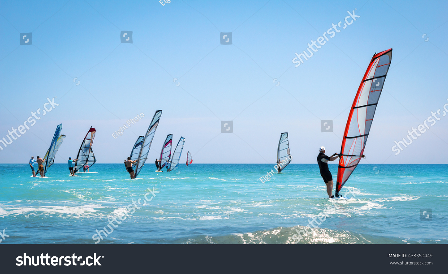 Windsurfing sails on the blue sea