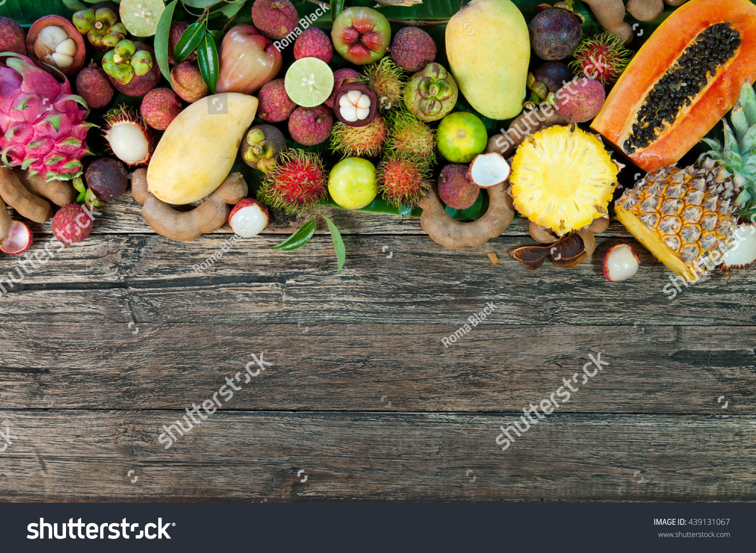 Fresh tropical fruit on wood on top