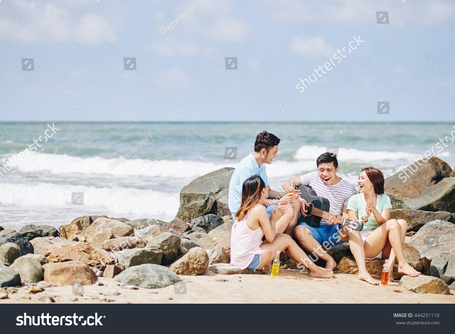 Somebody taking photo of friends jumping at the beach