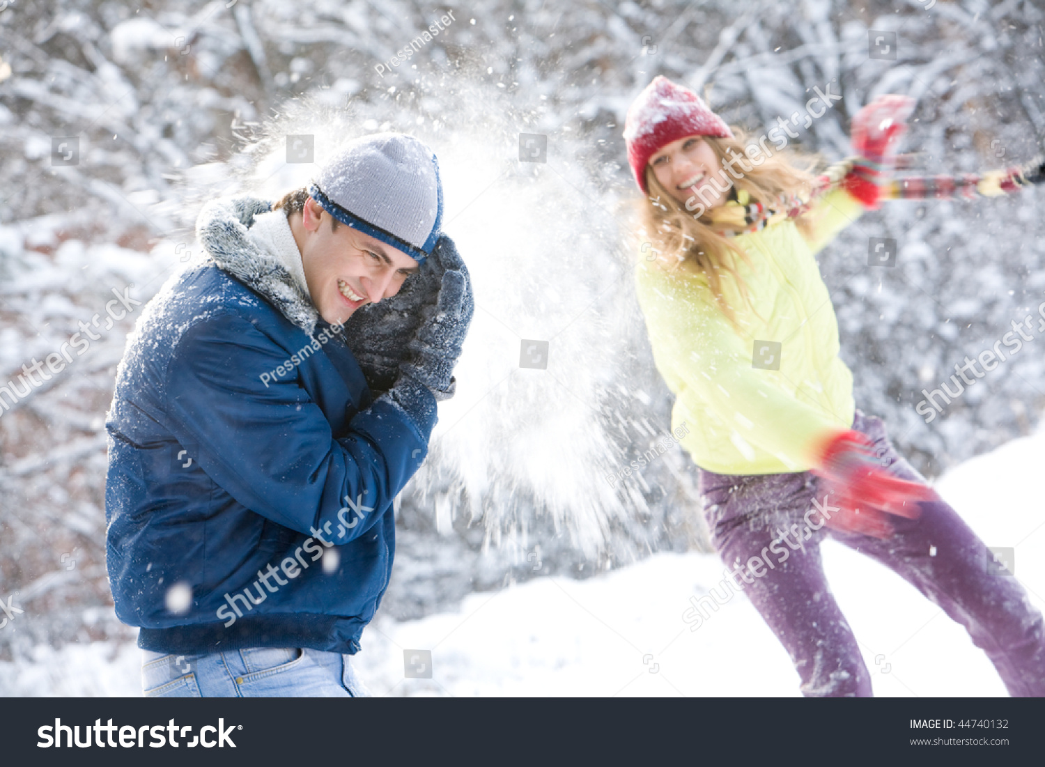 Image of young woman flinging the snowball into her boyfriend