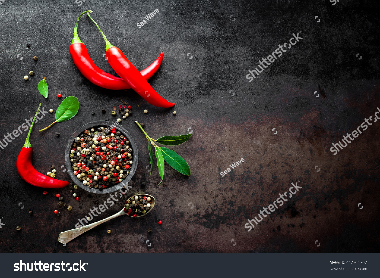 red hot chili pepper corns and pods on dark vintage metal culinary background  top view