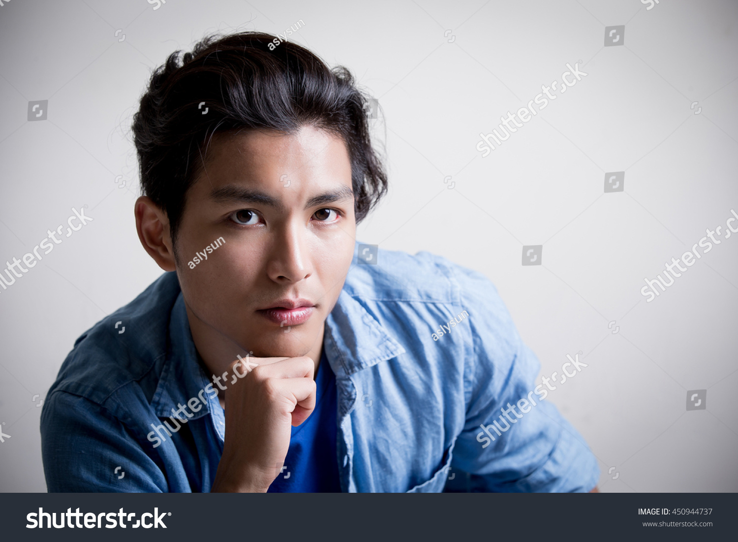 handsome man wear denim shirt and look serious isolated white background asian