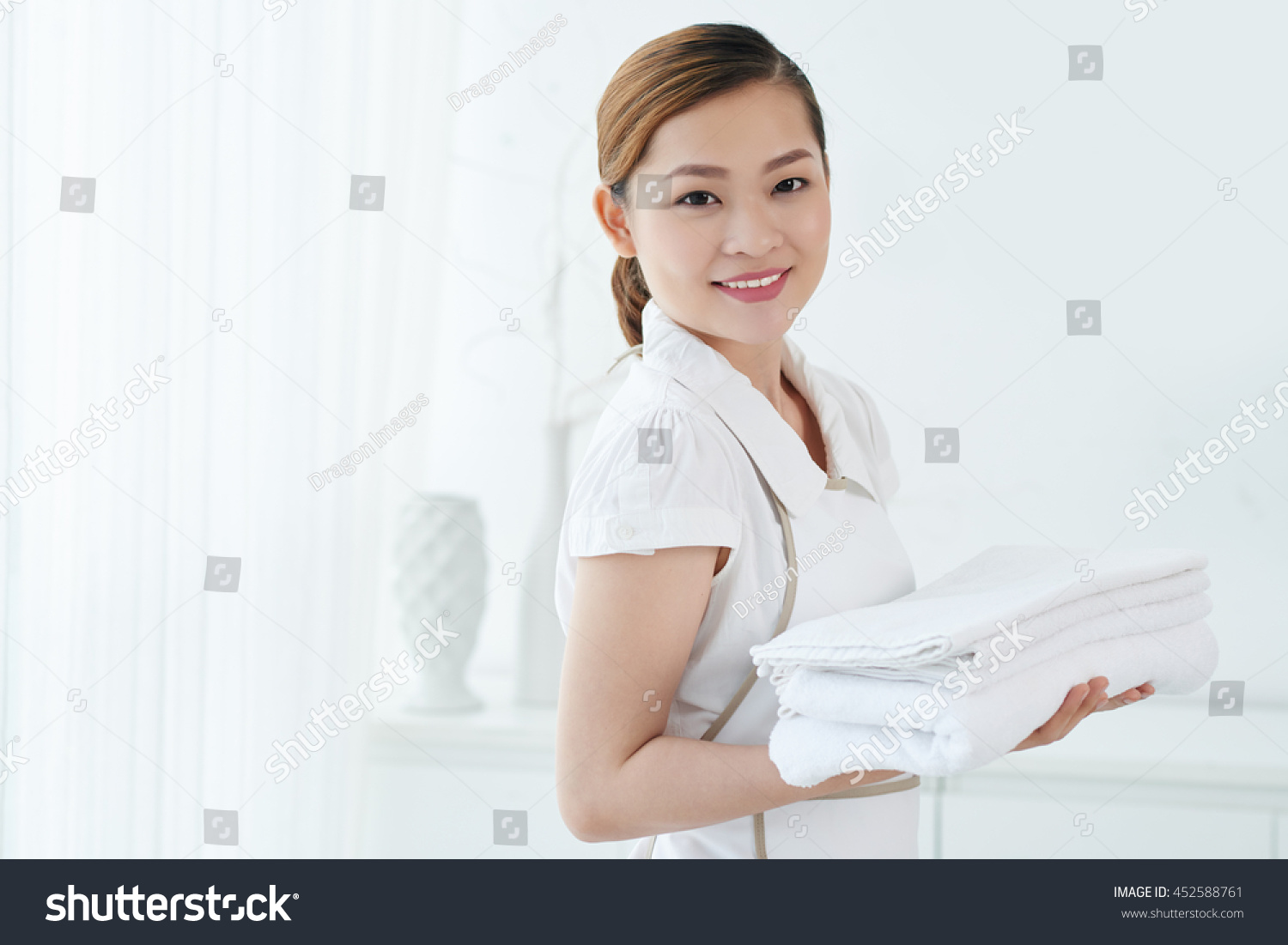 Lovely Vietnamese maid holding fresh white towels