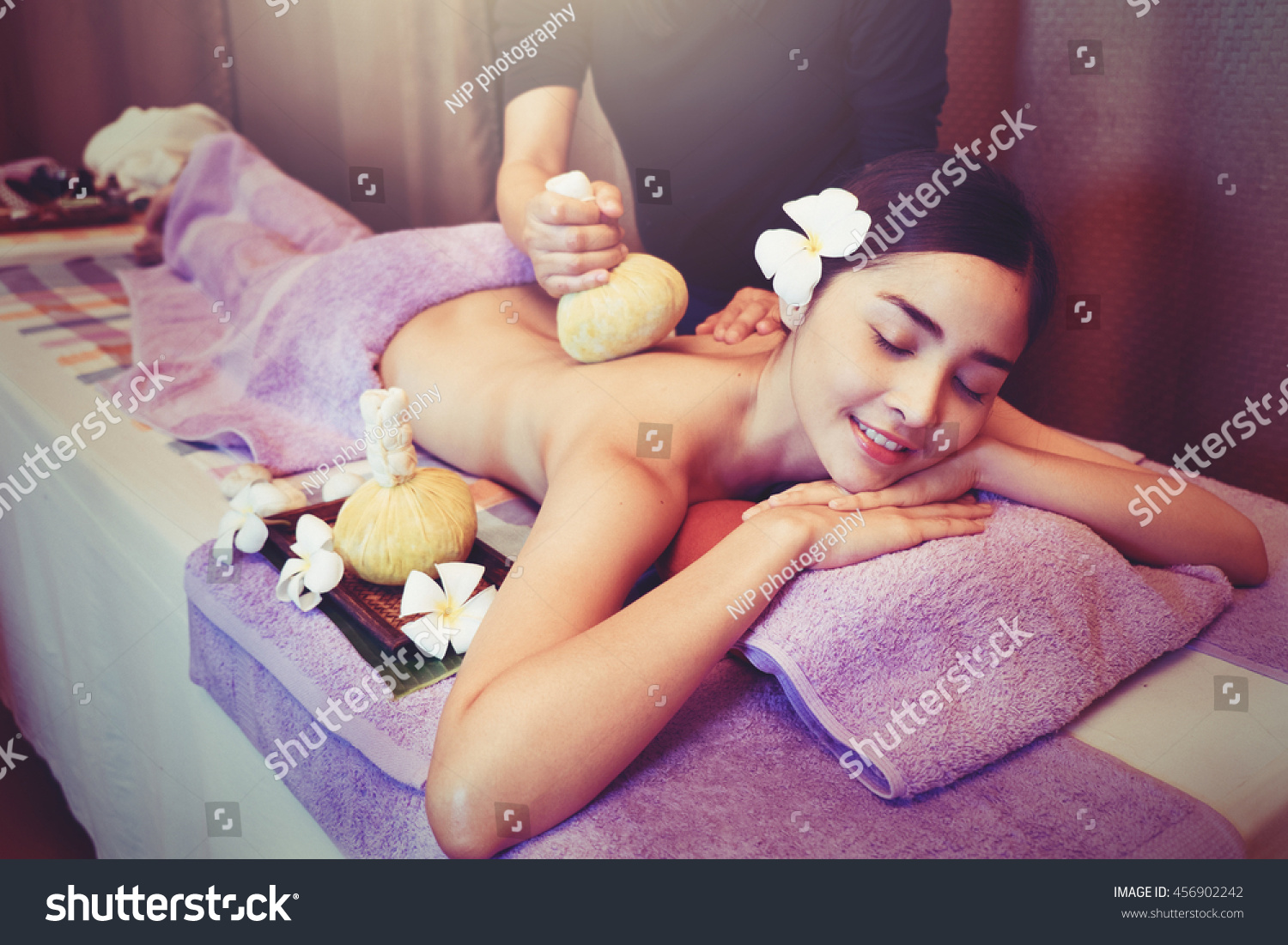 Asian woman getting thai herbal compress massage in spa    Vintage Style 