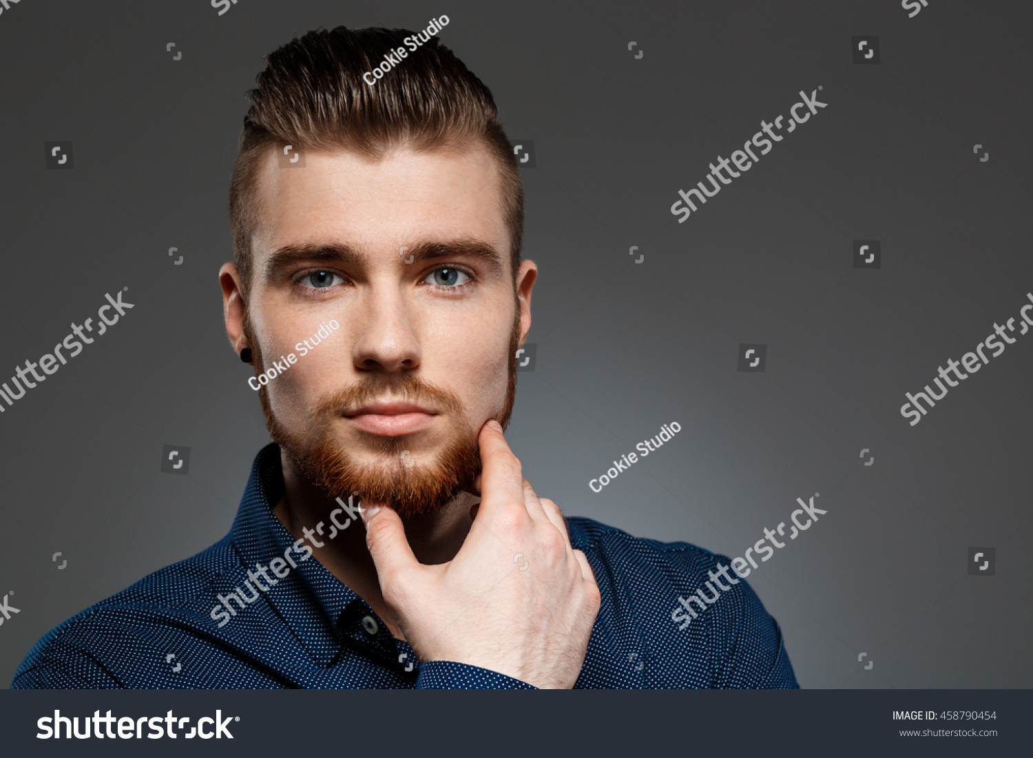 Young successful businessman posing over dark background. Copy space.