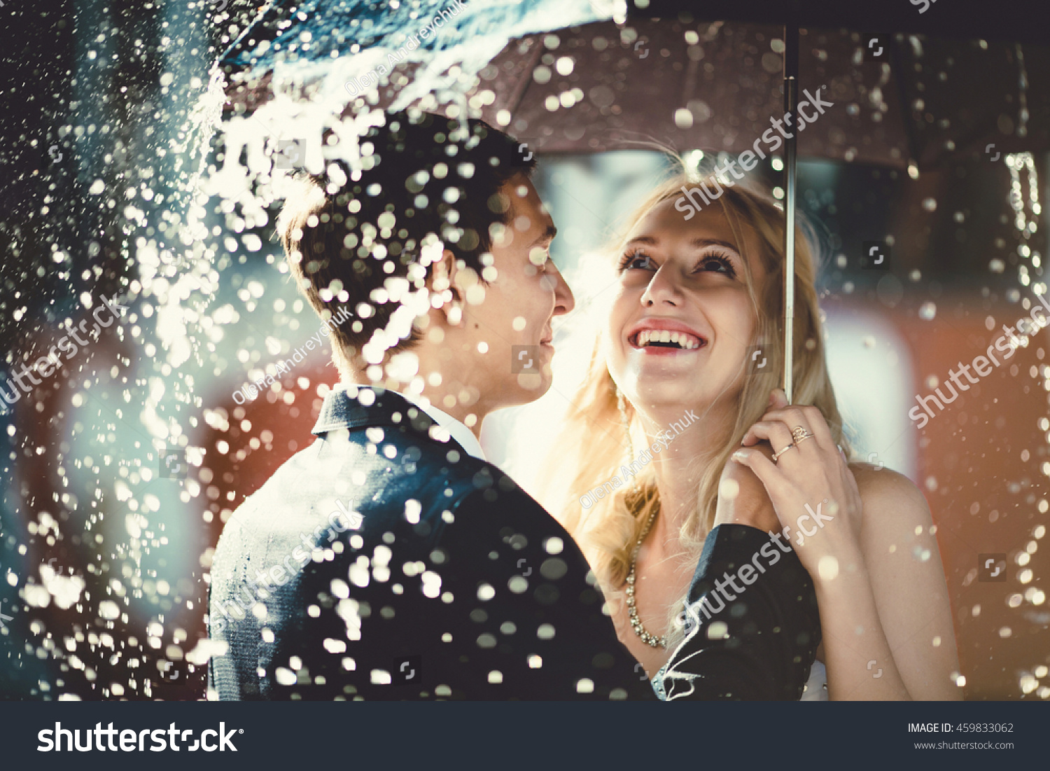 young couple standing under a big umbrella