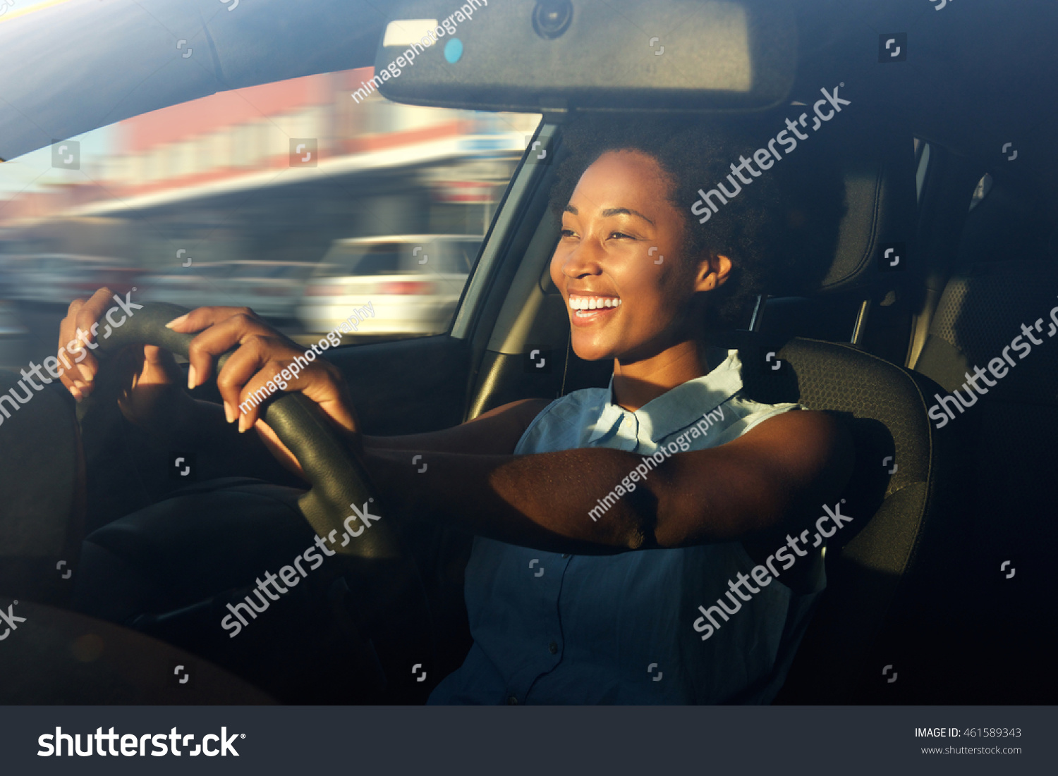 Portrait of smiling young african american woman driving a car