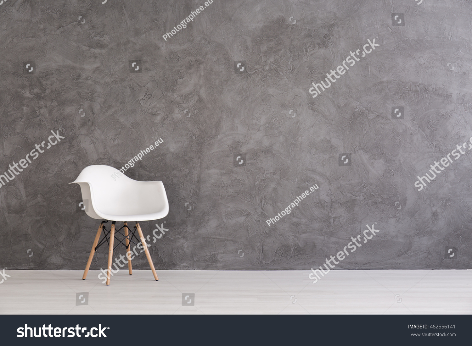 White plastic chair on a background of a gray concrete wall
