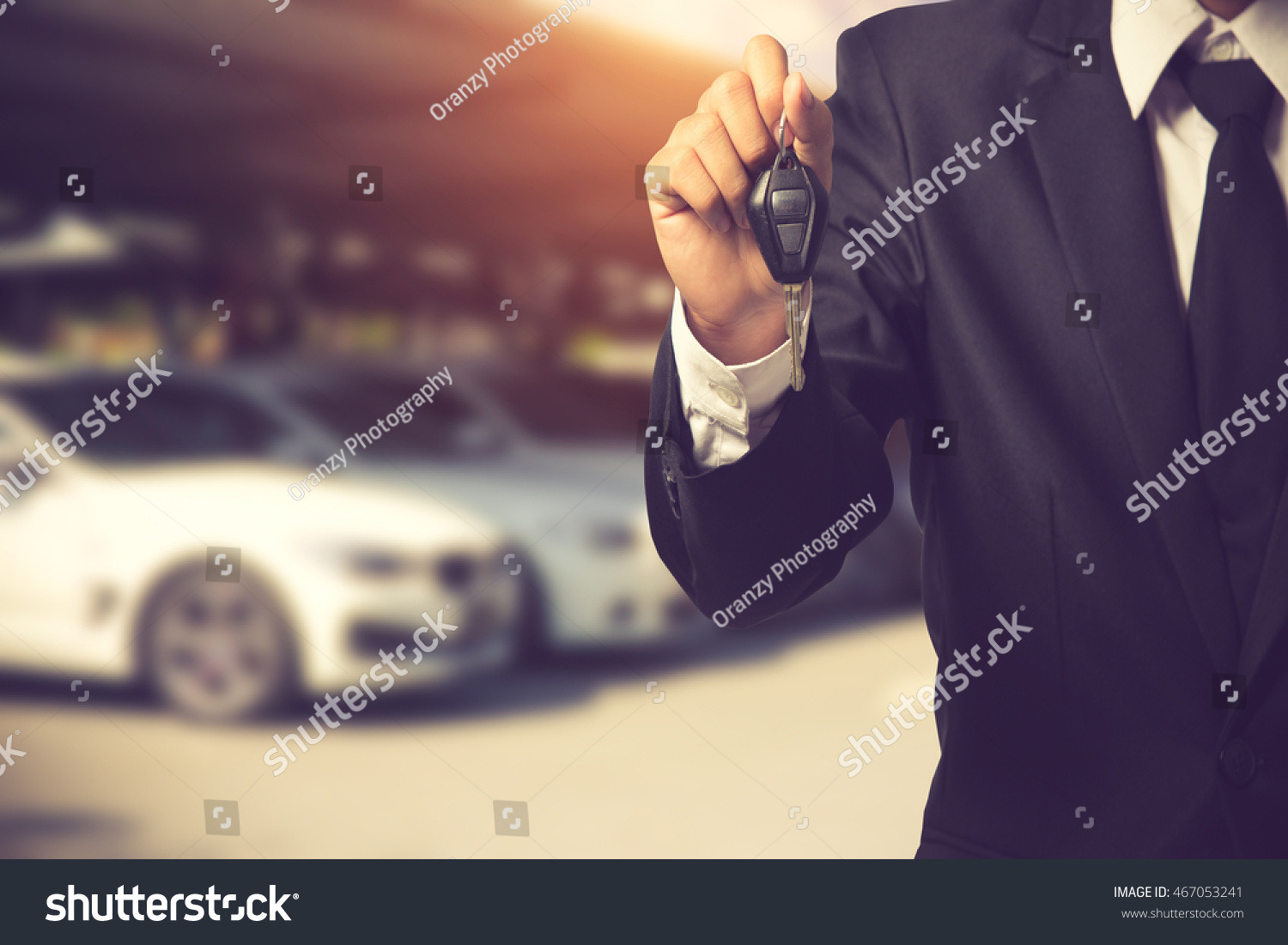businessman showing a car key - car sale & rental business concept.Vintage color