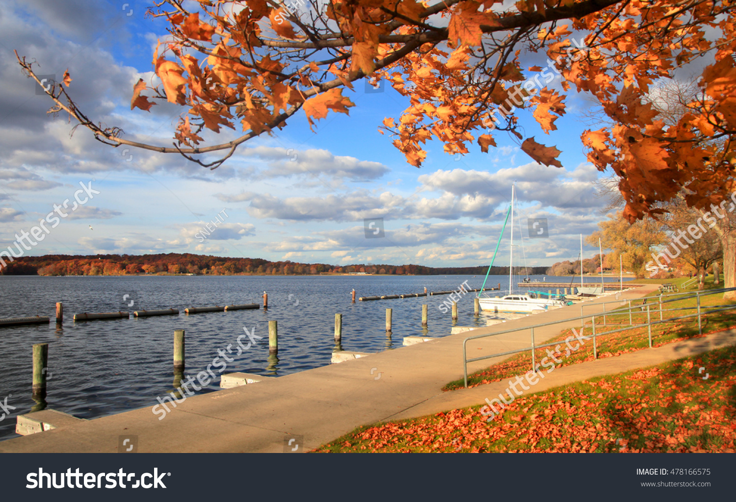 Boats docked in a lake by the autumn trees