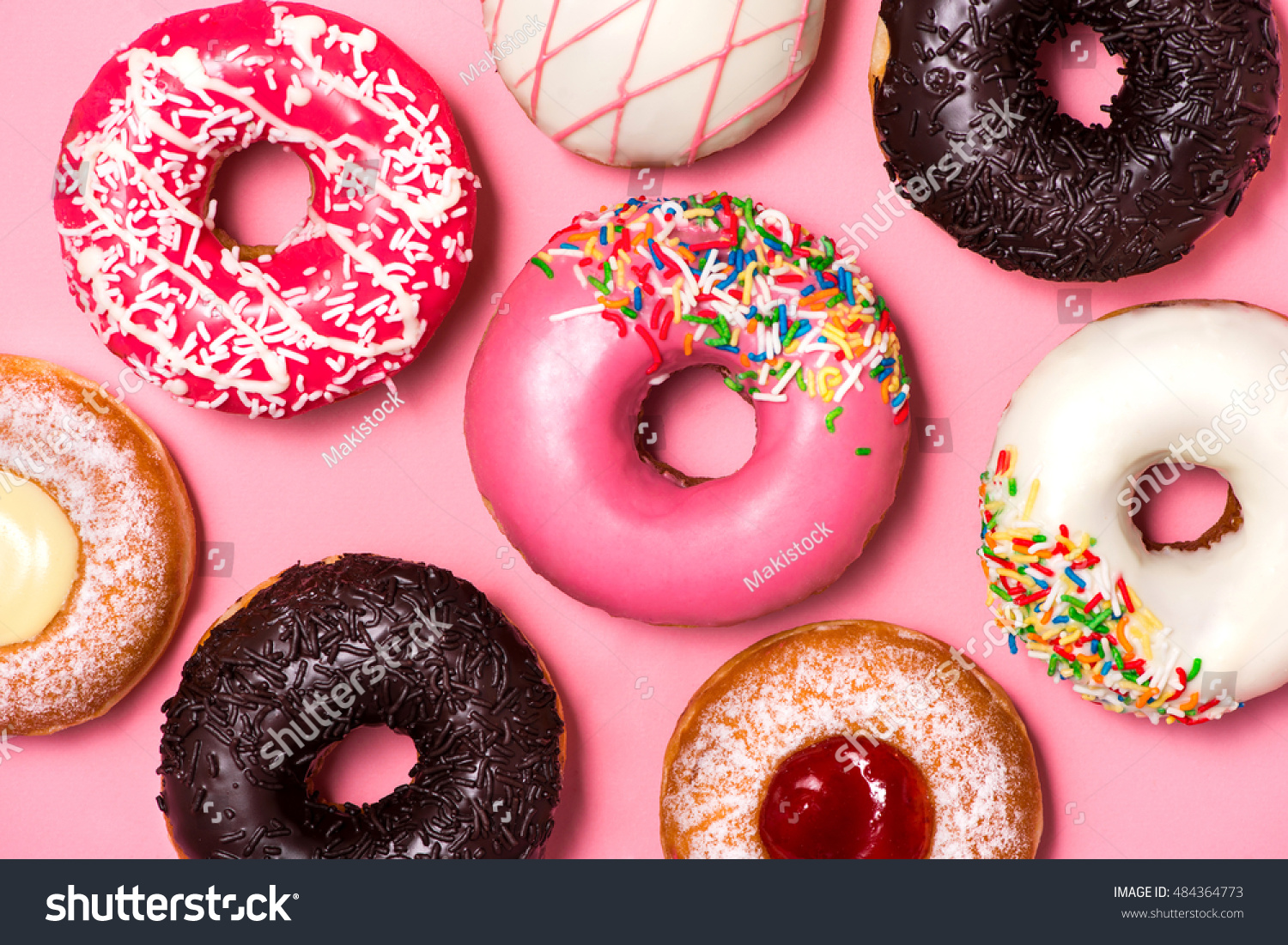 Donuts with icing on pastel pink background. Sweet donuts.
