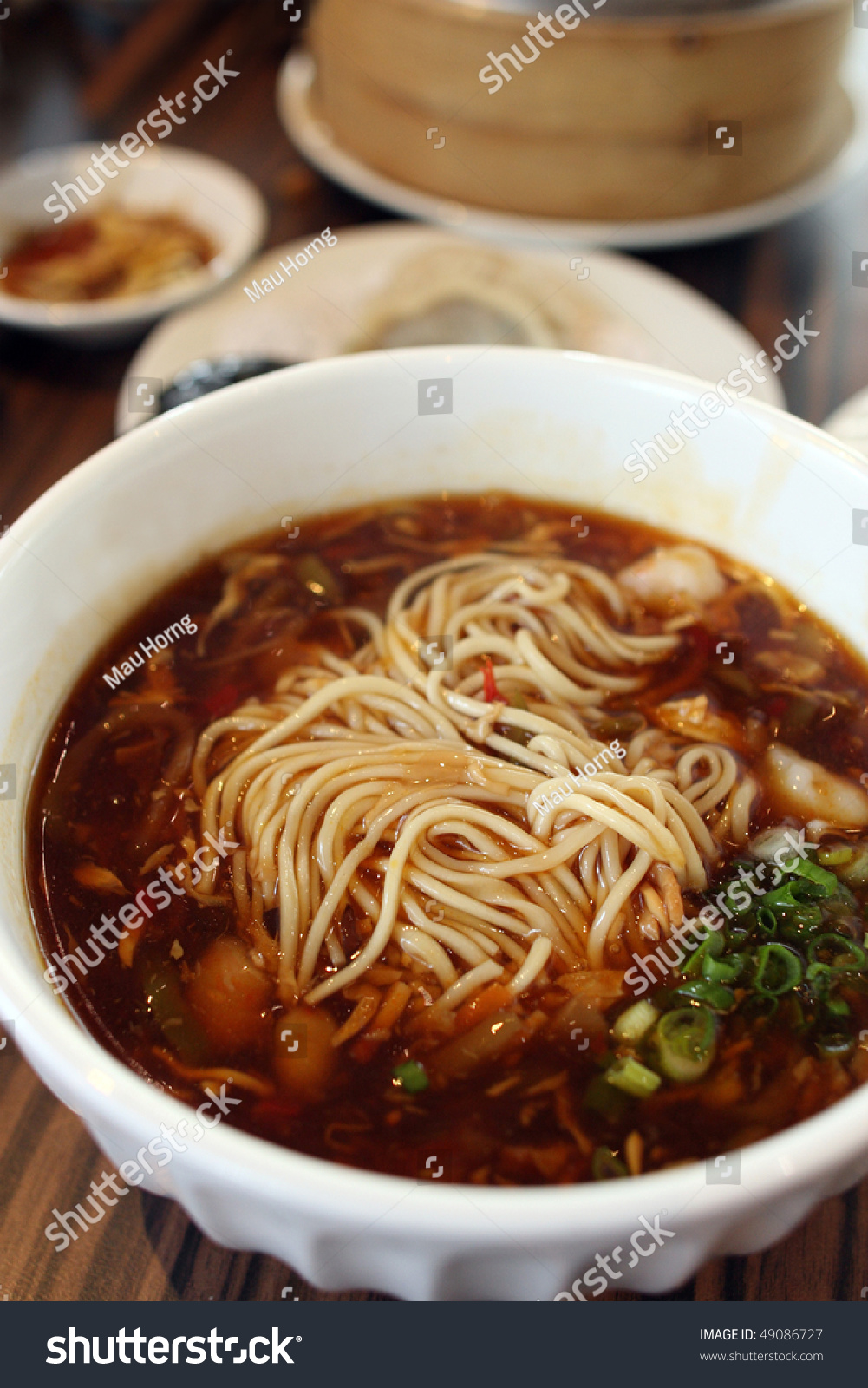 Close up of Sichuan Ramen with other dishes on table.
