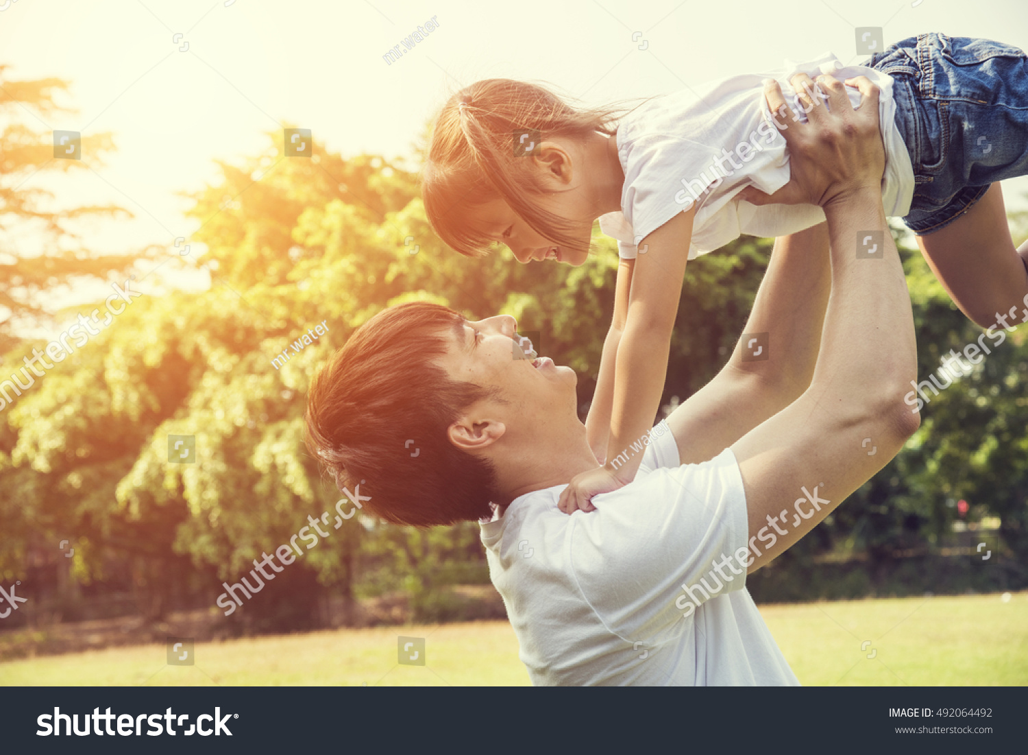 Portrait of happy asian little girl with her father in the garden