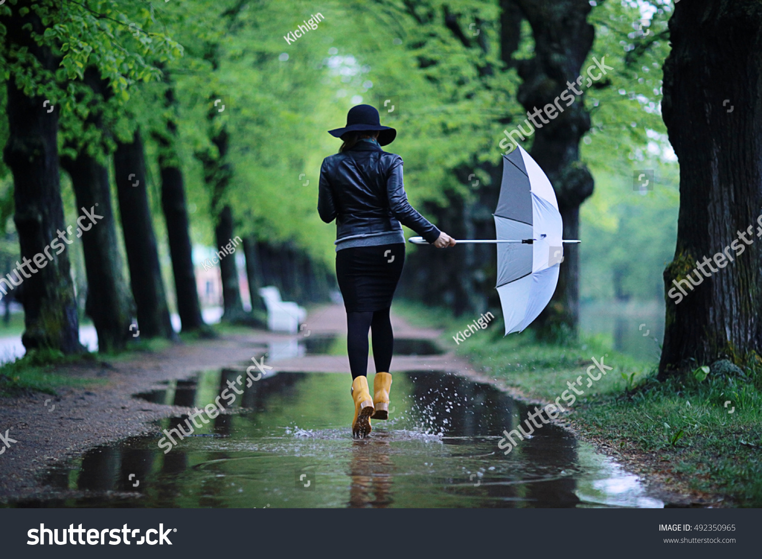 feet in rubber boots rain puddle city