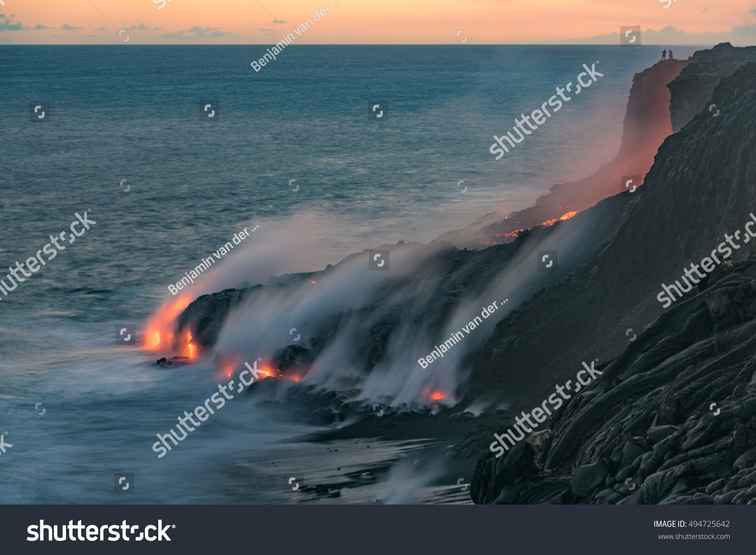 Lava from the Kilauea volcano  flows into the Pacific ocean near Kalapana  while people watch the spectacle from up above at Volcanoes National Park on the Big Island of Hawaii. 