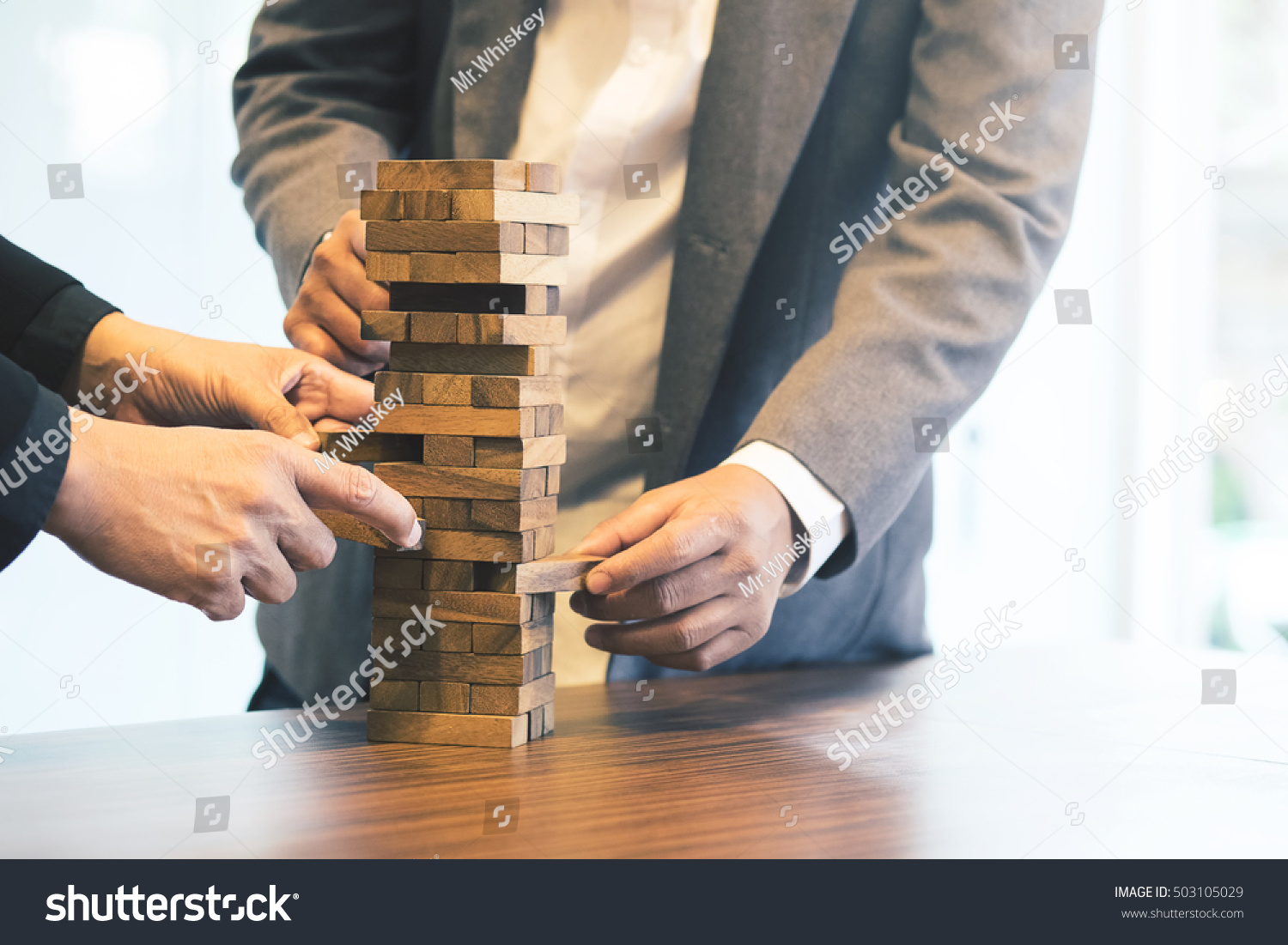 Close up of hands helping build a building of wooden pieces. Businesspeople planning a new business strategy. Business team generate new ideas with wooden bricks. Business risk concept vintage tone.