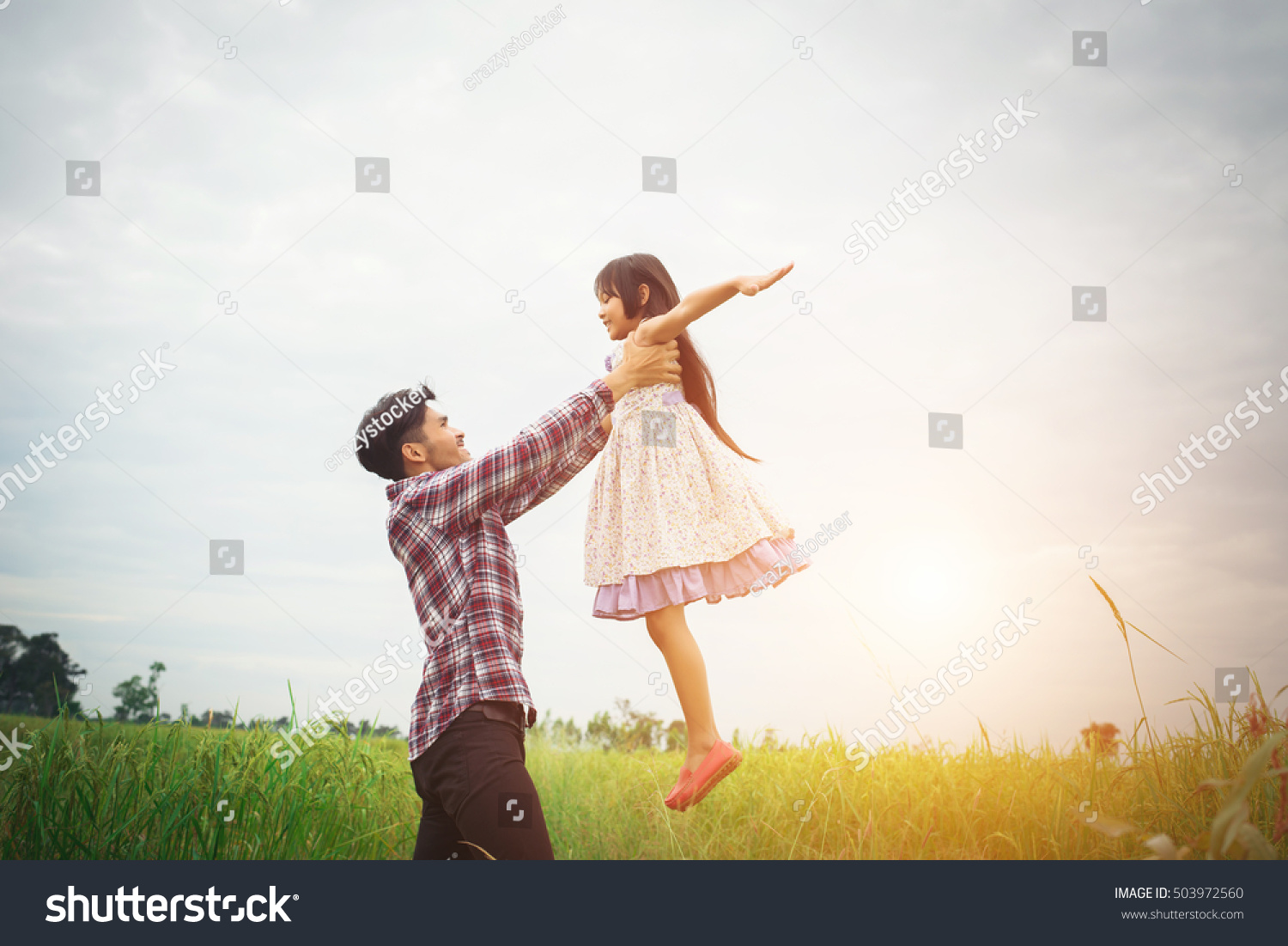 Daddy carrying his daughter with nature and sunlight  enjoyment family.