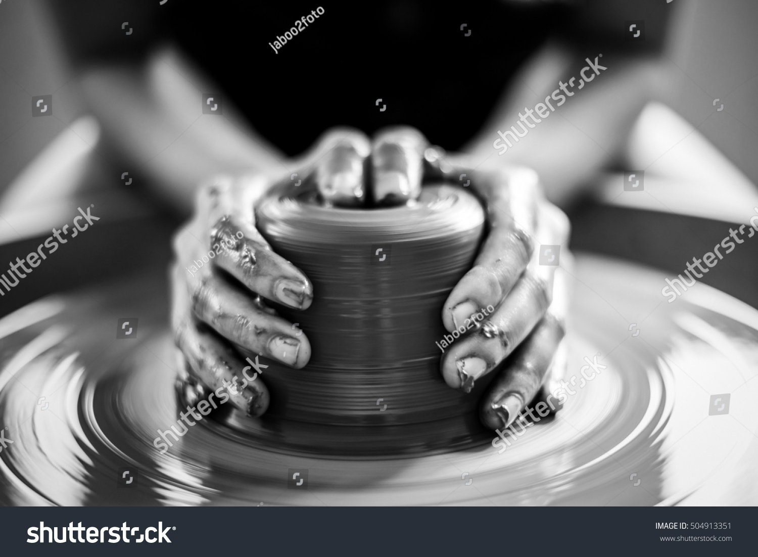 woman potter hands makes on the pottery wheel clay pot   black and white 