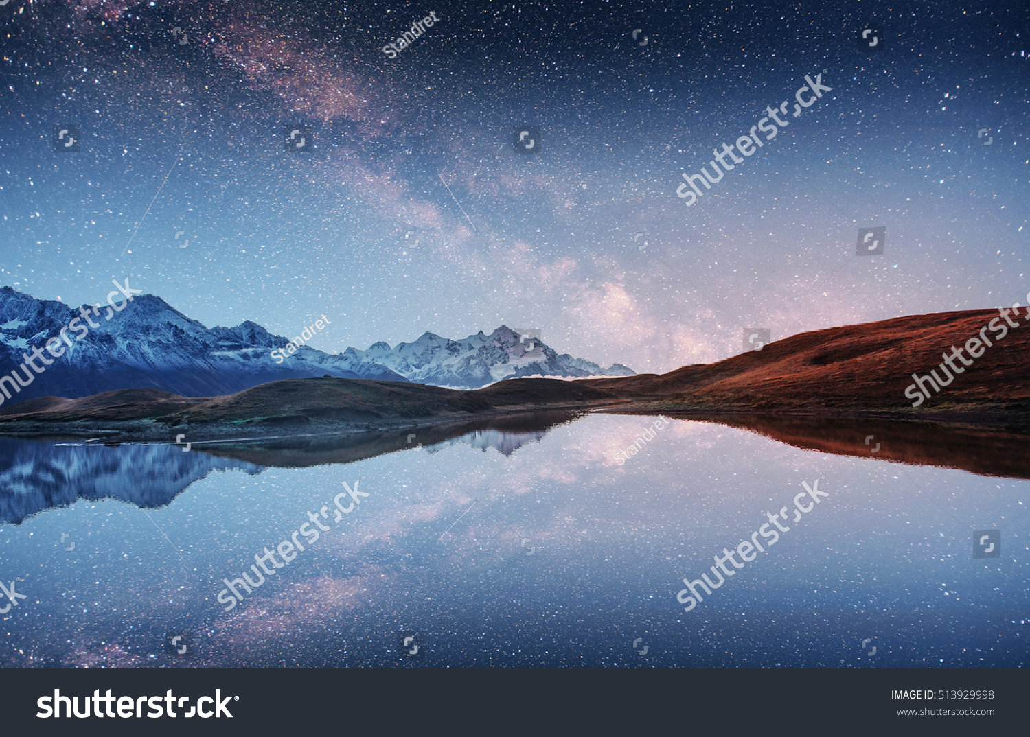 Fantastic starry sky and the Milky Way over the mountain lake. A ...