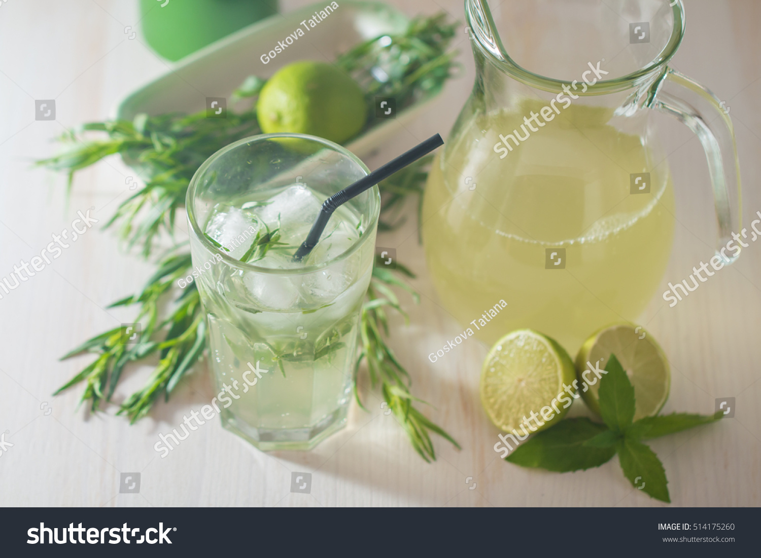 homemade lemonade from lime and tarragon on white wooden background