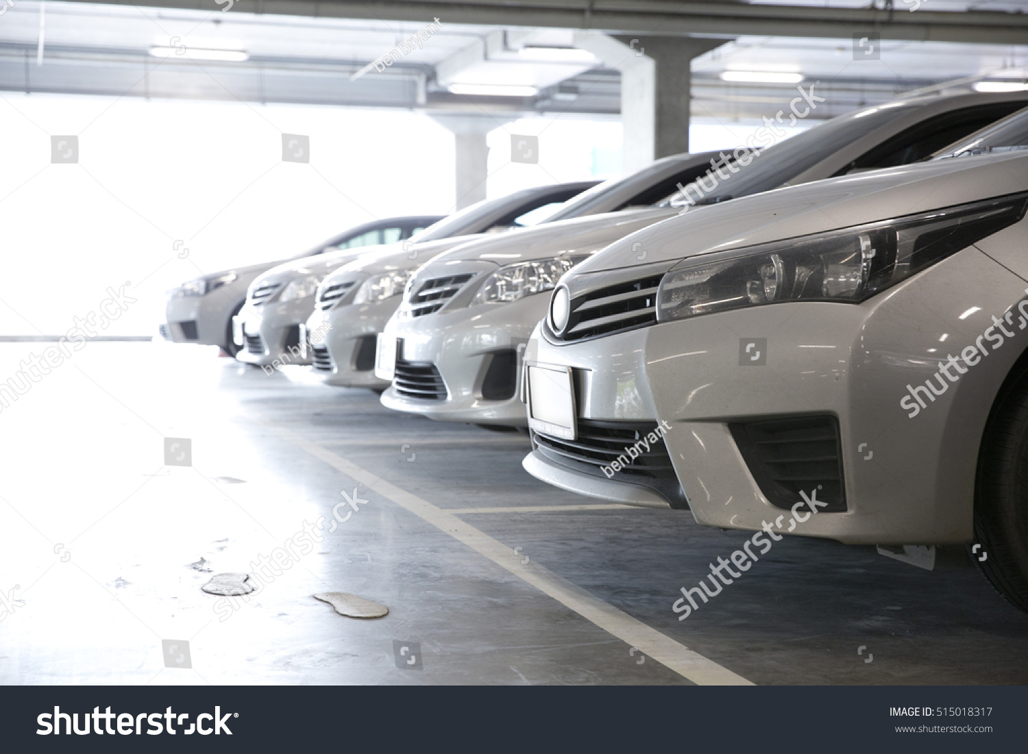 Parking garage  interior with a few parked cars.