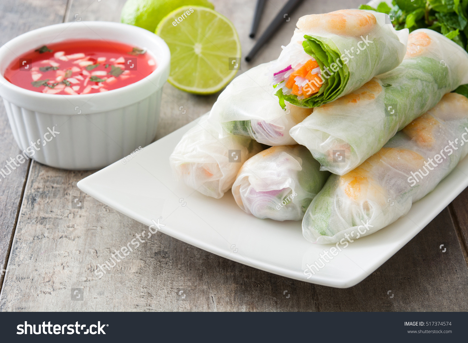 Vietnamese rolls with vegetables  rice noodles and prawns on wooden background
