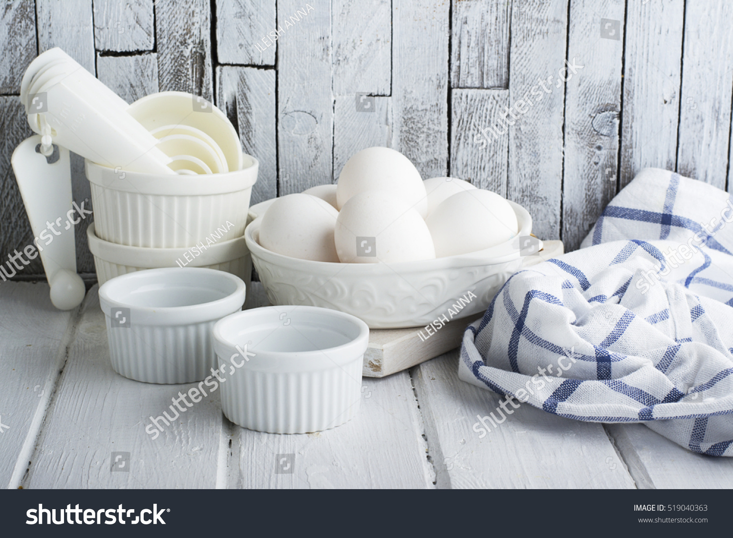 Ceramic white form for baking and village eggs on the kitchen simple white wooden background with blue dining cotton towel. Horizontal. selective focus